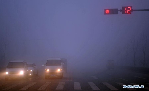 Motorcars have to turn on fog lights amid fog and smog in Baoding, north China's Hebei Province, Feb. 28, 2013. The province was hit by heavy fog on Feb. 28 morning and the local meteorological bureau has issued an orange alert for the fog. (Xinhua/Zhu Xudong)