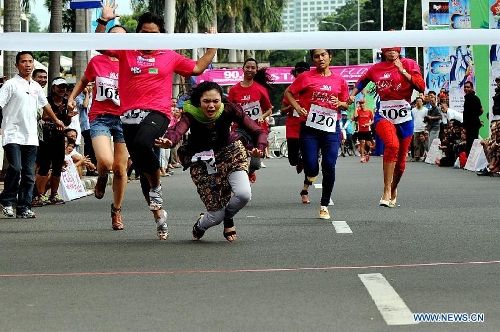  Indonesian women wearing high-heel shoes compete during Fun With Your Heels race in Jakarta, Indonesia, April 14, 2013. Runners were required to wear 7cm-high-heel shoes during the race. (Xinhua/Agung Kuncahya B.)