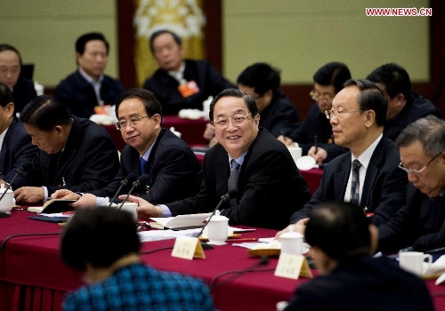 Yu Zhengsheng (C), a Standing Committee member of the Political Bureau of the Communist Party of China (CPC) Central Committee, who is also the executive chairperson of the presidium of the first session of the 12th National Committee of the Chinese People's Political Consultative Conference (CPPCC), visits members of the 12th CPPCC National Committee from the CPC and joins their panel discussion in Beijing, capital of China, March 4, 2013. (Xinhua/Li Xueren)