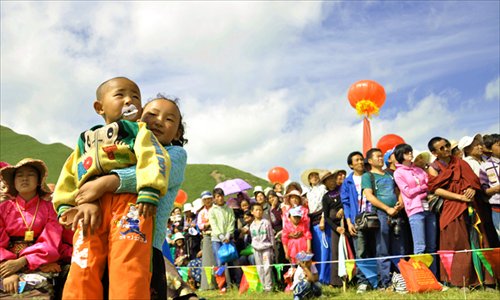 A girl holds her younger brother to give him a better view of the show after sneaking past the security line.
