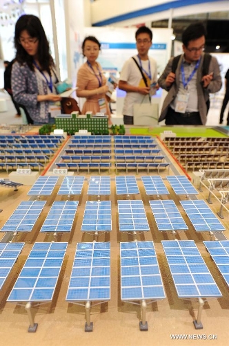Visitors watch the models of photovoltaic products during the 2013 international photovoltaic exhibition in east China's Shanghai Municipality, May 14, 2013. The four-day exhibition, with the participation of more than 1,500 exhibitors, opened here Tuesday. (Xinhua/Lai Xinlin) 