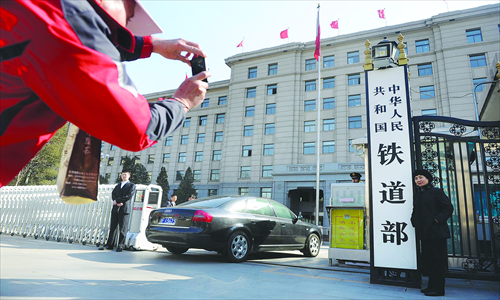 People pose for photos in front of the Ministry of Railways in Beijing. According to a report on the State Council institutional reform, the ministry will be dismantled into administrative and commercial arms to reduce bureaucracy and improve railway service efficiency. Photo: Li Hao/GT