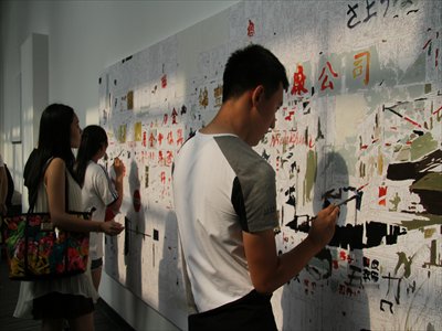 Visitors to exhibition <i>A Better Tomorrow</i> add their touches to  Shen Shaomin's work <i>Before I See You</i> on Sunday. Photo: Courtesy of Wu Man