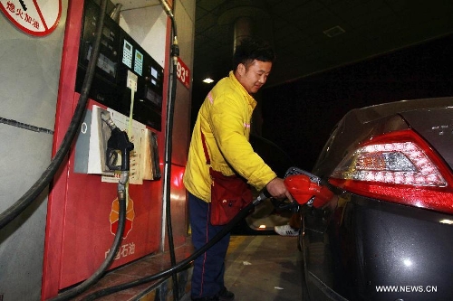 A worker refuels a car at a gas station in east China's Shanghai Municipality, April 25, 2013. Retail prices of gasoline were cut by 395 yuan (63.32 U.S. dollars) per tonne and diesel by 400 yuan per tonne from Thursday. (Xinhua/Ding Ting) 