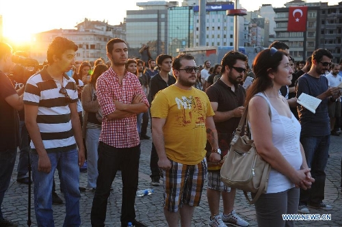Protestors stand silently in front of Ataturk culture centre near the Taksim Square in Istanbul, Turkey, on June 18, 2013. Hundreds of people stood silently from morning to evening on Tuesday here to protest against the government. Nationwide protests began when an environmentalists' rally aiming to preserve Gezi Park adjacent to Taksim Square in Istanbul met fierce police crackdown, which triggered a wave of fiery opposition against the government's policies. (Xinhua/Lu Zhe) 