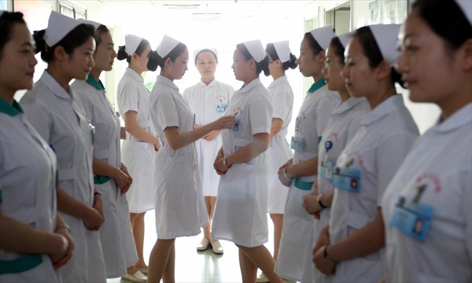An instructor inspects nurses' outfits during a training session at a training base of the PLA General Hospital in Beijing. Photo: CFP