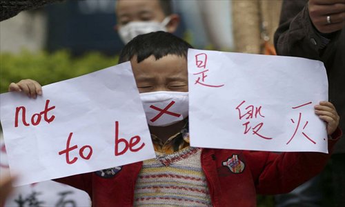 A child wearing a face mask participates in protests against the construction of an oil refinery in the nearby city of Anning, Yunnan Province on May 4. Nearly 3,000 Kunming residents participated in the protests. Photo: china.com