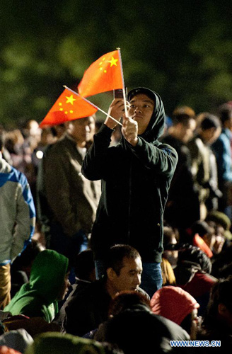 People watch the national flag raising ceremony at the Tian'anmen Square in Beijing, capital of China, October 1, 2012. Tens of thousands of people gathered at the Tian'anmen Square to watch the national flag raising ceremony at dawn on October 1, in celebration of the 63rd anniversary of the founding of the People's Republic of China. Photo: Xinhua