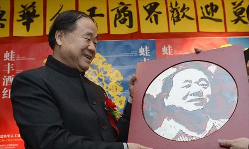 Chinese writer Mo Yan, the 2012 Nobel Prize winner for literature, receives a gift during a reception by Chinese entrepreneurs in Stockholm, capital of Sweden, December 8, 2012. Photo: Xinhua