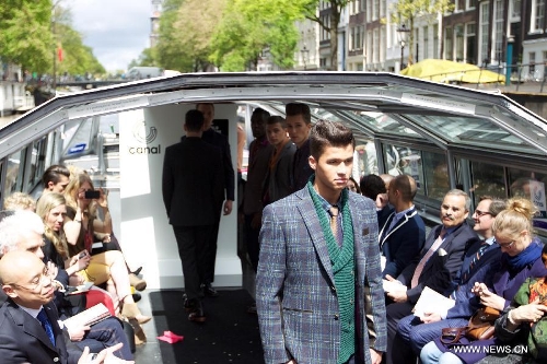 A model presents a creation on a canal boat in Amsterdam, the Netherlands, on May 22, 2013. The event