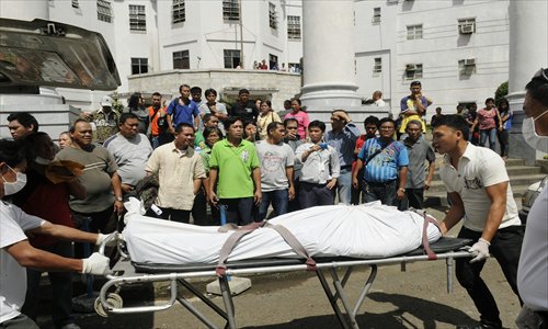 Funeral parlor workers push a stretcher carrying one of the two people shot dead by a Canadian national inside a court room, in Cebu City, central Philippines on Tuesday. He shot dead the two, including a lawyer, using a pistol he smuggled inside the court as he went on trial for petty mischief, police said. Photo: AFP
