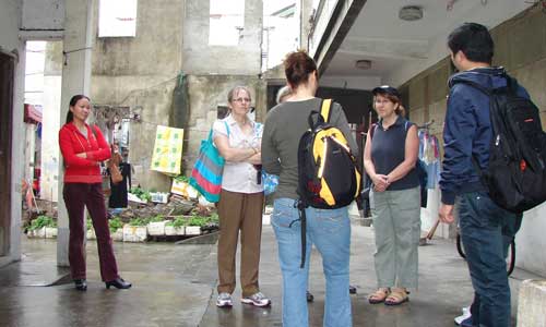 Tourists ponder the lives of migrant workers during a visit to their neighborhood.