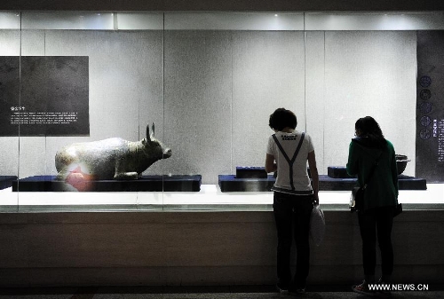 Visitors appreciate cultural relics of the Kingdom of Xia on display in an exhibition in Changchun, capital of northeast China's Jilin Province, May 15, 2013. An exhibition of the cultural relics of the Kingdom of Xia, a regime founded in west China in 1038, was held here on Wednesday, in which more than 100 cultural relics of the kingdom excavated since the founding of the People's Republic of China in 1949 were shown to the public. (Xinhua/Xu Chang)&nbsp; 