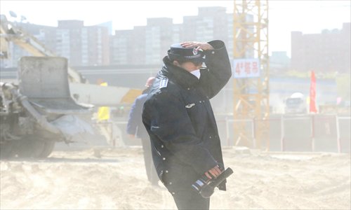 Beijing Municipal Bureau of City Administration and Law Enforcement raids a construction site in the Olympic Culture Business Park, as it failed to cover earth piles on Monday, which saw strong winds. The construction site will face a fine of up to 70,000 yuan ($11,284). Photo: CFP