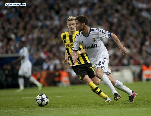 Real Madrid's Xabi Alonso (R) runs with the ball during the UEFA Champions League semi-final second leg football match against Borussian Dortmund in Madrid, capital of Spain, April 30, 2013. Borussia Dortmund qualified for the Champions League final, beating Real Madrid 4-3 on aggregate despite a 2-0 loss Tuesday. (Xinhua/Xie Haining) 
