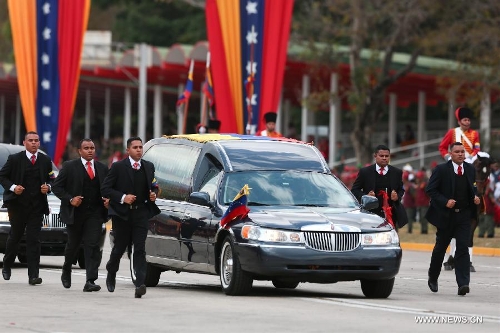 The body of late Venezuelan President Hugo Chavez is carried from the Military Academy to the Mountain Barracks, in the city of Caracas, capital of Venezuela, on March 15, 2013. Hundreds of thousands of Venezuelans Friday marched alongside the casket of their late President Hugo Chavez, as his remains were taken to the mountaintop barracks he once called home and today houses the Historic Military Museum. (Xinhua/AVN)