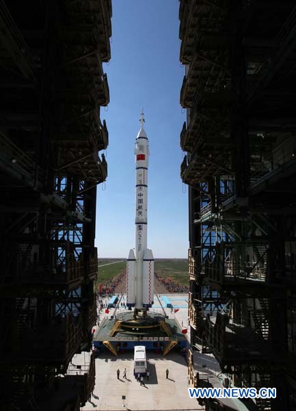 The Shenzhou-9 manned spacecraft, the Long March-2F rocket, and the escape tower wait to be vertically transferred to the launch pad at the Jiuquan Satellite Launch Center in northwest China's Gansu Province, June 9, 2012. China will launch its Shenzhou-9 manned spacecraft sometime in mid-June to perform the country's first manned space docking mission with the orbiting Tiangong-1 space lab module, a spokesperson with the country's manned space program said Saturday. Photo: Xinhua