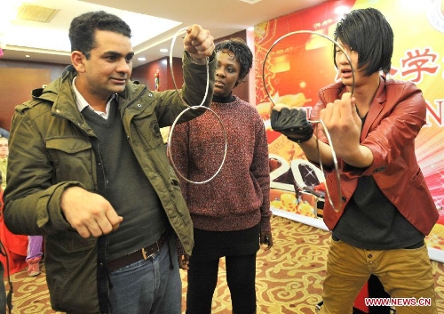 Overseas students learn tricks of magic in an activity to celebrate the Chinese New Year at the Nanjing Agricultural University in Nanjing, capital of east China's Jiangsu Province, Feb. 4, 2013. More than 50 overseas students from over 20 countries and regions experienced Chinese traditional cultural activities with local students. (Xinhua)&nbsp; 