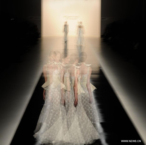 The multi-exposure photo shows models presenting creations of Acquastudio during Sao Paulo Fashion Week in Sao Paulo, Brazil, March 19, 2013. The Sao Paulo Fashion Week Summer 2013/14 started here on Monday and will last for five days. (Xinhua/Weng Xinyang) 