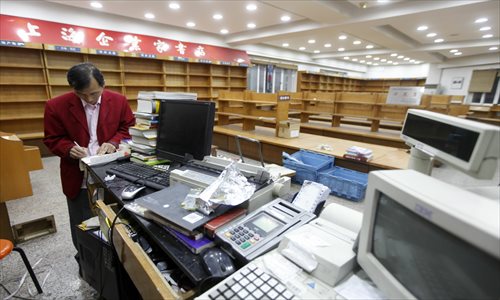 An employee of the Xinhua bookstore on Sichuan Road North goes over the inventory before the store shut its doors Tuesday. The store, which opened 90 years ago, closed due to operating losses. The bookstore was where Chen Yun, China's former senior leader, joined the revolution in 1925. Photo: Cai Xianmin/GT