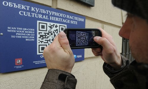 A man in Moscow, Russia, scans a QR code on Monday using a smartphone, which allowed him to find out more information about a historical building and cultural heritage site on Tverskaya, Moscow's main street. Photo: IC 
