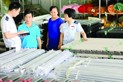 Tax officials talk with employees of a curtain rod manufacturer in Tonglu county, East China's Zhejiang Province. Photo: IC