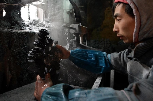  A craftsman named Hu Yongzhong washes a semi-finished handicraft made of chrysanthemum stone in a workshop in Enshi, central China's Hubei Province, Jan. 12, 2013. 