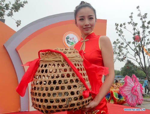 A ritual girl shows a basket of newly-harvested Chinese mitten crabs of the Yangcheng Lake in Suzhou, east China's Jiangsu Province, September 22, 2012. The fishing and sale of Chinese mitten crabs of Yangcheng Lake this autumn was officially started on Saturday. Photo: Xinhua
