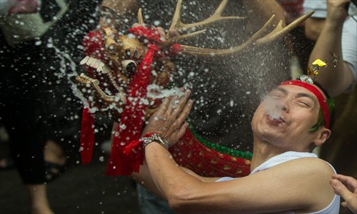 A man performs the drunk dragon dance at the Drunk Dragon Festival in Macao on Friday. The drunk dragon dance, in which performers drink rice wine while dancing, is a traditional performance by fish sellers in Macao. The fish sellers take a day off on April 9 of the lunar calendar, which falls on Saturday this year.  Photo: IC