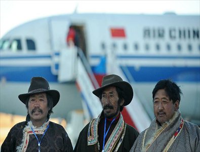 Staff members pose for group photos in front of the test flight at the Daochengyading Airport in Daocheng County of the Tibetan Autonomous Prefecture of Garze, southwest China's Sichuan Province, November 23, 2012. The first test flight of the airport successfully landed Friday. With the height of 4,411 meters above sea level, the Daochengyading Airport becomes the highest civil airport in the world. (Xinhua/Xue Yubin)