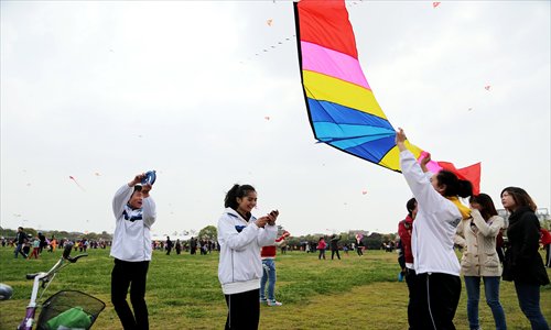 Middle school students fly a kite at the Fengxian Bay Tourist Area Sunday. Every year, the area sponsors a series of activities, which this year includes a kite flying competition, a dragon boat race, an international music festival and an equestrian performance. Photo: Yang Hui/GT