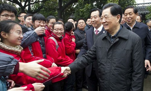 Photo released on December 29, 2012 shows Chinese President Hu Jintao (R, front) shakes hands with students of Taizhou High School in Taizhou, east China's Jiangsu Province.