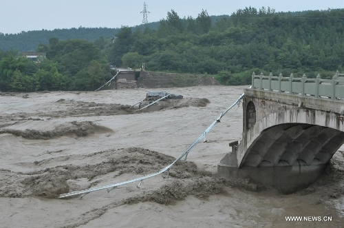 Photo taken on July 9, 2013 shows the collapsed old Qinglian Bridge across the Tongkou River in Jiangyou City, southwest China's Sichuan Province. An unknown number of vehicles and pedestrians fell into the river after the bridge collapsed on the morning of July 9. The water level of the river rose significantly over the past two days due to continuous rainfalls in the region. (Xinhua)