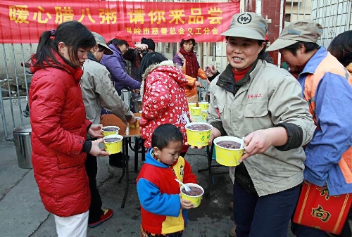 Citizens get free porridge from voluntary workers in Taizhou, east China's Zhejiang Province, Jan. 19, 2013. Voluntary workers here distributed Laba porridge for free on Jan. 19, the eighth day of the 12th lunar month or the day of Laba Festival. The Laba Festival is regarded as a prelude to the Spring Festival, or Chinese Lunar New Year, the most important occasion of family reunion, which falls on Feb. 10 of this year. Drinking Laba porridge on the day of Laba is a traditional custom in China. (Xinhua/Liu Zhenqing) 