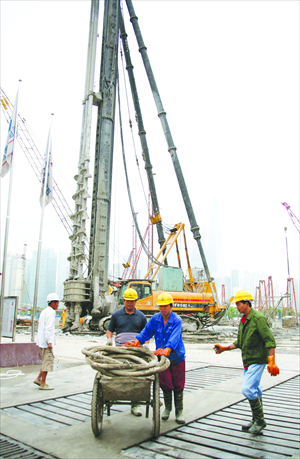 Men work on the Bund development project that is being fought over by Fosun and SOHO China, in Shanghai on June 6. Photo: CFP
