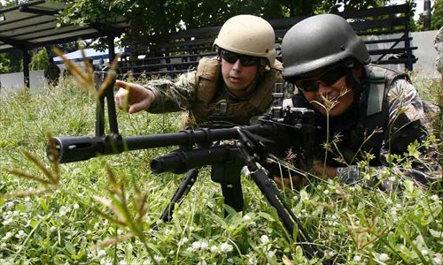 A US navy soldier (L) instructs his Philippine counterpart during a joint military exercises between the Philippines and the United States at the South China Sea, June 28, 2013. The Philippines and U.S. Naval forces began joint military exercises codenamed Cooperation Afloat Readiness and Training (CARAT) at the South China Sea on June 27 to enhance the capability of both sides through practical exercises and lectures. Photo: Xinhua