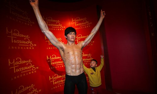 A visitor mimics a wax sculpture of Olympic swimming champion Sun Yang at Madame Tussauds Shanghai museum Monday. Photo: Cai Xianmin/GT