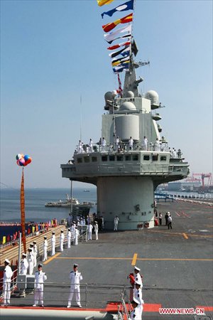 Military officers stand onboard China's aircraft carrier 