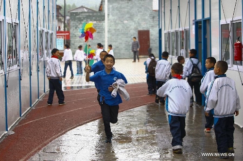 Students of the central primary school of Shangli Town play with pinwheels during class break in Shangli, Lushan County, southwest China's Sichuan Province, May 16, 2013. The schoolhouses of the Shangli Town Center School were destroyed in the 7.0-magnitude earthquake taken place in Lushan on April 20, leaving more than 1, 200 students to have classes in newly built prefab houses. (Xinhua/Liu Xiao)&nbsp; 