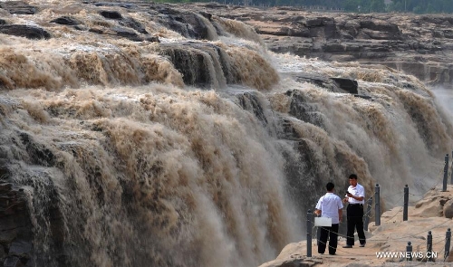 People gather to watch the Hukou Waterfall of the Yellow River in Jixian County, north China's Shanxi Province, June 30, 2013. (Xinhua/Lv Guiming) 