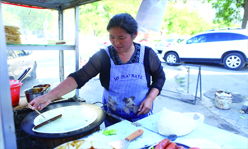 A vendor makes jianbing in Beijing. This is one of the most famous and traditional foods to eat in the morning. 
