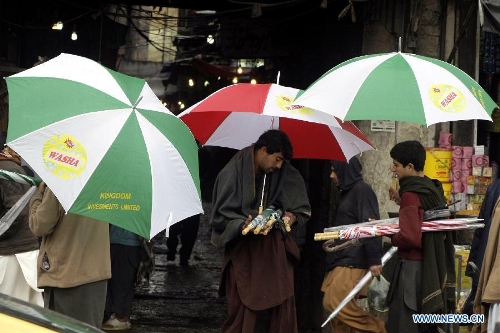 People hold umbrellas in northwest Pakistan's Peshawar Feb. 6, 2013. At least 17 people were killed, 31 injured and many others displaced after moderate to heavy rainfall lashed several areas of Pakistan over the last 72 hours, local TV Dunya reported on Tuesday. (Xinhua/Umar Qayyum) 