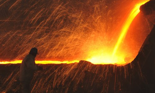 A worker walks past an operating blast furnace. Photo: CFP
