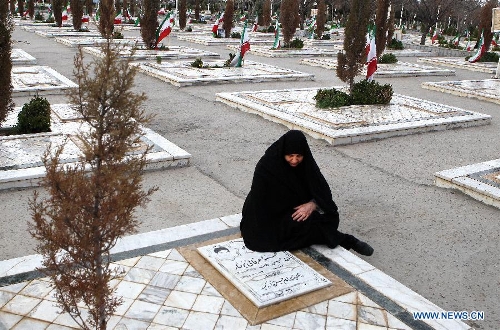 A woman sit at a grave of a soldier who was killed during the 1980-88 Iran-Iraq war, at the Behesht-e Reza cemetery in Mashhad city, northeastern Iran, March 25, 2013. Iranians visited the cemetery to commemorate soldiers who were killed during the Iran-Iraq war, during the Iranian New Year holidays. (Xinhua/Ahmad Halabisaz)