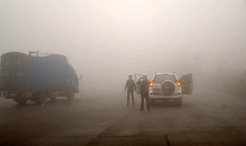 A man takes photos on the fog-shrouded Kaifeng Road in Guilin, southwest China's Guangxi Zhuang Autonomous Region, Jan. 13, 2013. Dense fog on Sunday hit China's east and central regions from the northeast to the south, causing serious air pollution. (Xinhua/Lu Bo'an) 