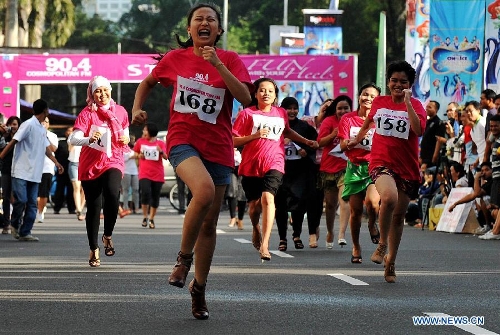  Indonesian women wearing high-heel shoes compete during Fun With Your Heels race in Jakarta, Indonesia, April 14, 2013. Runners were required to wear 7cm-high-heel shoes during the race. (Xinhua/Agung Kuncahya B.)