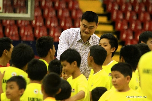 Former Chinese basketball superstar Yao Ming (Back) greets children during a basketball clinic in Pasig City, the Philippines, May 5, 2013. Yao and his Shanghai Sharks are in Manila on a friendly visit. They will attend two exhibition games respectively with the Smart Gilas Team and the Philippine Basketball Association (PBA) Selection. (Xinhua/Rouelle Umali) 