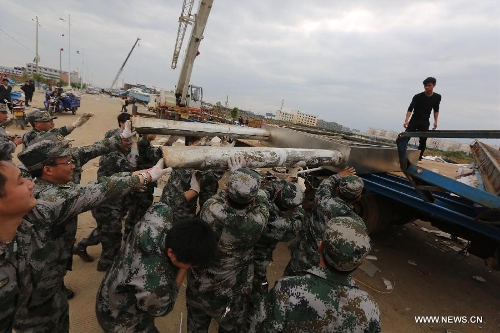 &nbsp;Rescuers clear wind-torn billboards in Daoxian County, central China's Hunan Province, March 20, 2013. Three people were killed and 52 others were injured by a tornado that struck the county before dawn on Wednesday. The local meteorological observatory said the wind speed of the tornado reached 30.7 meters per second, a record for the observatory. (Xinhua/Guo Guoquan) 