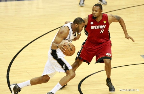 San Antonio Spurs Tracy McGrady (L) drives the ball during the Game 3 of the 2013 NBA Finals against Miami Heat in San Antonio, Texas, the United States, June 11, 2013. San Antonio Spurs won 113-77. (Xinhua/Song Qiong)