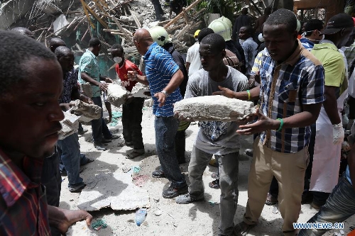 Local residents clean up the building collapse site in downtown of Dar es Salaam, Tanzania, March 29, 2013. A 16-storey building on Friday morning collapsed in Dar es Salaam, with more than 60 people got trapped in the debris. No casualties have been reported as of noon local time. (Xinhua/Zhang Ping)